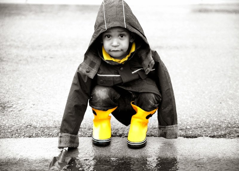 Ребенок в желтых сапогах на черном фоне