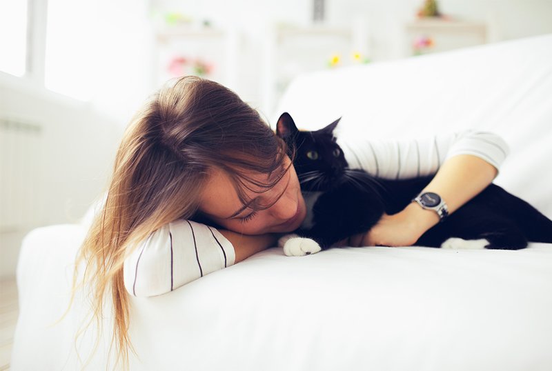 Девушка обнимает черного кота